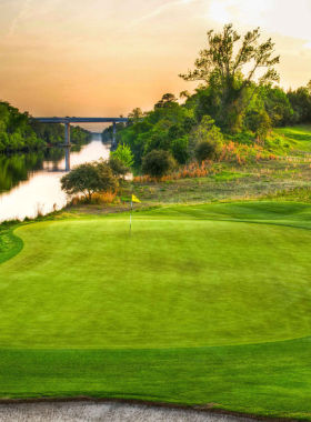  A scenic view of the Greg Norman-designed golf course at Barefoot Resort in Myrtle Beach, with lush greens and challenging water features. Golfers enjoy a pristine environment while experiencing world-class golfing.