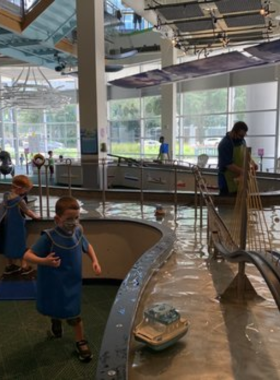  A child playing in an interactive exhibit at Glazer Children’s Museum, surrounded by colorful displays and engaging activities that encourage learning and creativity.

