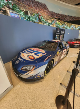  This image shows that visitors are discovering the history of NASCAR through immersive, interactive exhibits at the NASCAR Hall of Fame, learning about famous drivers and iconic cars in racing history.