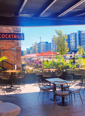 This image shows that guests are enjoying a diverse range of local food at Optimist Hall, a vibrant food hall in Charlotte featuring trendy food vendors and modern interior design.

