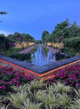 This image shows that visitors are strolling through the beautifully landscaped gardens at Daniel Stowe Botanical Garden, exploring a variety of vibrant blooms and lush plant life in a tranquil setting.