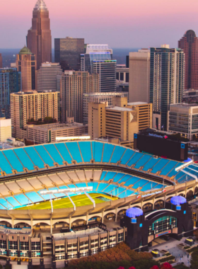 This image shows that passionate fans are cheering for the Carolina Panthers at Bank of America Stadium, enjoying an exciting NFL football game in a packed stadium atmosphere.

