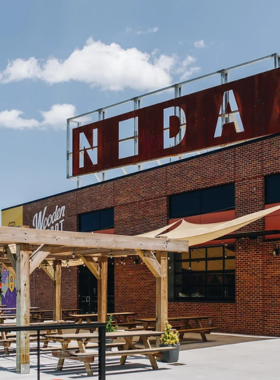 This image shows that visitors are exploring the NoDa Arts District, known for its vibrant street art and unique galleries, where they are appreciating local culture and artistic expression through murals and exhibitions.