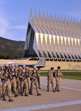 This image shows the iconic Cadet Chapel at the U.S. Air Force Academy, a striking architectural masterpiece with sharp spires against a clear blue sky.