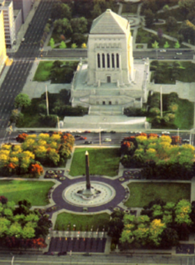 This image shows the Indiana War Memorial Plaza, featuring a fountain and large statues commemorating veterans in a peaceful setting."