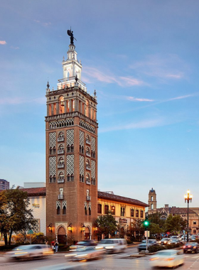 "This image shows a bustling day at Country Club Plaza in Kansas City, with people walking along the stylish shopping area, surrounded by Spanish-style architecture."