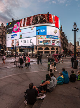 This image shows Piccadilly Circus with its famous neon lights and lively evening crowd.