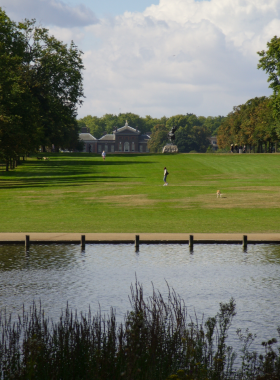 This image shows a peaceful pathway in Kensington Gardens with scenic greenery and open spaces.