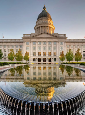 "This image shows that the Utah State Capitol is a grand building with a dome and columns, surrounded by well-kept grounds."