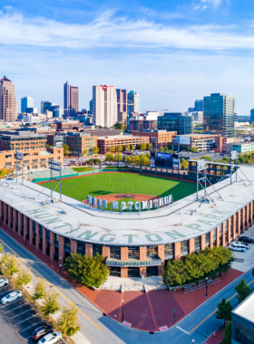  "This image shows Huntington Park in Columbus, Ohio, with its large green baseball field, packed stands, and fans cheering, creating a family-friendly atmosphere during a Columbus Clippers game."