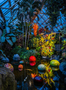 "This image shows Franklin Park Conservatory’s lush gardens and impressive glasshouses in Columbus, Ohio, with visitors exploring exotic plants, colorful flower displays, and tranquil paths, offering a peaceful nature experience."