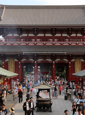 This image shows the vibrant Tsukiji Outer Market where visitors enjoy fresh sushi for breakfast. The market is bustling with people, vendors selling seafood, and colorful stalls offering sushi delicacies. The fresh seafood on display highlights the authenticity and variety of Tokyo’s seafood cuisine.