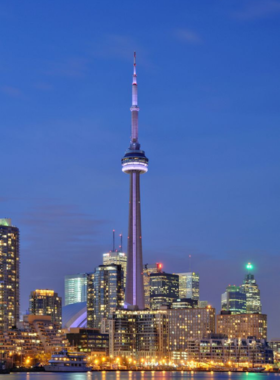 This image shows visitors standing on the CN Tower’s observation deck, admiring a panoramic view of Toronto’s skyline and Lake Ontario. The CN Tower, a symbol of Toronto, provides an unforgettable vantage point for seeing the city’s expanse, while its EdgeWalk experience offers thrill-seekers an open-air adventure at impressive heights.