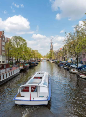 This image shows a boat cruise along Amsterdam's canals, with tourists enjoying scenic views of the city’s historic buildings, bridges, and the tranquil waterways.