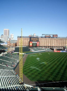 This image shows Oriole Park at Camden Yards, a retro-style baseball stadium with a view of the Baltimore skyline, showcasing its energetic atmosphere during a game day.