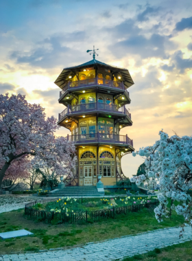 This image shows the iconic pagoda at Patterson Park surrounded by greenery, with pathways and people enjoying the serene and picturesque environment.