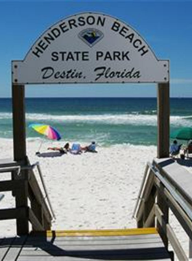 This image shows a serene sunset at Henderson Beach State Park, featuring pristine white sands, calm turquoise waves, and a peaceful coastal ambiance.

