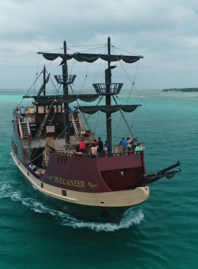 This image shows a pirate-themed boat cruising on calm waters, featuring children and families participating in fun pirate activities on deck.