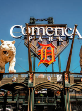 This image shows the lively atmosphere of Comerica Park during a Detroit Tigers game, with fans cheering and scenic city views.
