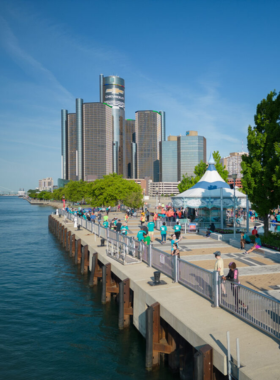 This image shows the serene views along the Detroit Riverwalk, featuring walking paths, art installations, and the riverfront.