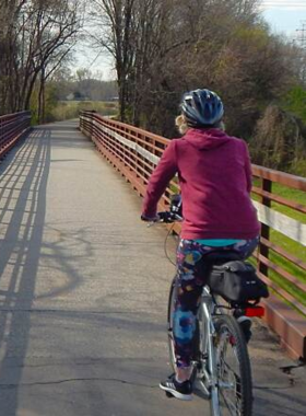  This image shows cyclists riding on the Prisma Health Swamp Rabbit Trail, a paved path lined with trees and scenic views. It highlights a popular spot for biking, walking, and enjoying nature.