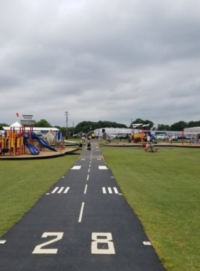 This image shows the aviation-themed playground at Runway Park, complete with slides and airplane models. The park combines fun for children with the thrill of watching planes take off nearby.