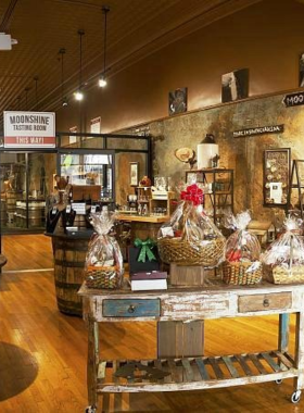 This image shows the rustic tasting room at Dark Corner Distillery, with bottles of handcrafted spirits on display. Visitors can learn about moonshine-making and sample local whiskey and gin varieties.