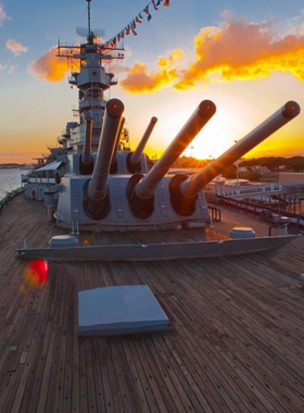 This image shows the Battleship Missouri Memorial, with visitors exploring the ship’s decks and admiring its historical significance. The ship is docked at Pearl Harbor, where Japan formally surrendered during World War II.