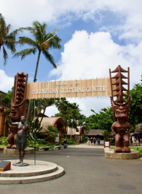 This image shows guests participating in a village tour at the Polynesian Cultural Center, learning about the traditions and cultures of the Pacific Islands. Visitors experience music, dance, and crafts while exploring the diverse villages.