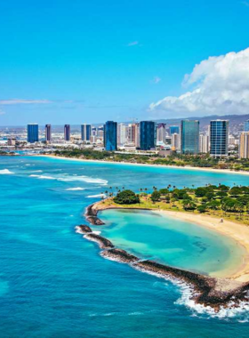 This image shows the beautiful sunset at Ala Moana Beach Park, with the sky painted in warm hues of orange and pink. The beach is peaceful, and people are enjoying the view while relaxing by the water.