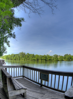 This image shows Ijams Nature Center in Knoxville, with lush green trails, people hiking and enjoying the beautiful natural landscape. The center offers an immersive experience in outdoor adventure and wildlife education.