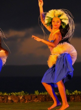 This image shows a traditional Hawaiian luau with hula dancers, fire performers, and a festive setting filled with cultural activities.