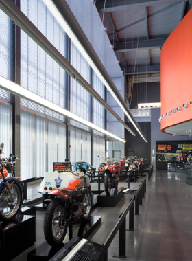 This image shows the front view of the Harley-Davidson Museum, a large modern building with a sleek design, showcasing motorcycles in an outdoor setting against a clear sky.