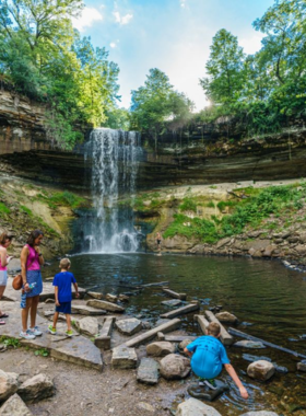 This image shows that Minnehaha Regional Park features the stunning Minnehaha Falls, picturesque trails, and beautiful green spaces for picnics and outdoor enjoyment in the heart of Minneapolis.