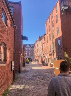 This image shows the charming cobblestone streets of Portland’s Old Port District, featuring colorful buildings, shops, and bustling restaurants by the waterfront.