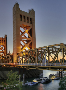 This image shows the Tower Bridge in Sacramento, with Old Sacramento’s historic waterfront visible in the background. The picturesque view highlights the blend of old architecture and modern infrastructure along the Sacramento River.