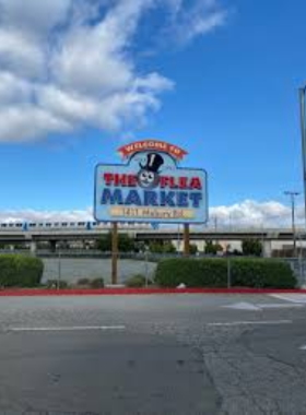 "This image shows a section of the San Jose Flea Market, featuring vendors selling vintage clothing, antiques, and unique handcrafted items, with people browsing for treasures in a lively outdoor setting."