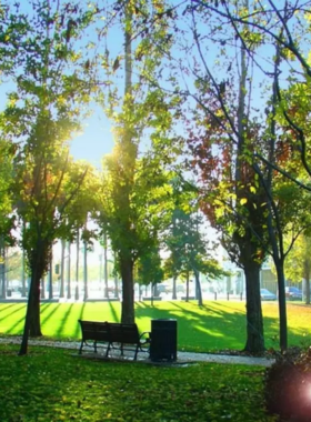 "This image shows a sunny day at Guadalupe River Park, where visitors enjoy walking trails, picturesque gardens, and families relaxing in picnic areas surrounded by natural beauty and art installations."