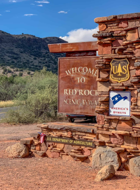 This image shows the breathtaking Red Rock Scenic Byway in Sedona, showcasing majestic red rock formations, open roads, and vast desert landscapes under a bright sky.