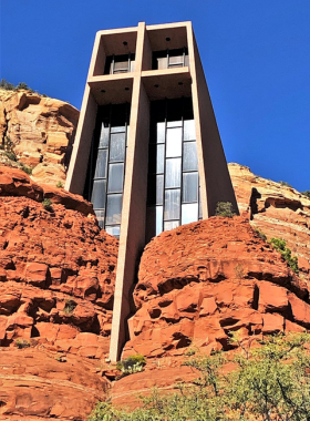 This image shows the Chapel of the Holy Cross, Sedona, nestled within the red rock cliffs, with its modern design contrasting beautifully against the natural desert backdrop.