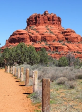  This image shows Bell Rock, one of Sedona’s most iconic landmarks, with hikers exploring its base and the towering red rock formation standing tall against the desert sky.