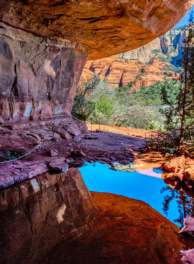 This image shows the Palatki Heritage Site in Sedona, featuring ancient cliff dwellings and vibrant pictographs from the Sinagua people, set amidst the region’s striking red rock cliffs.