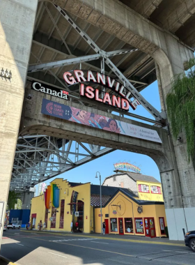 "This image shows the vibrant Granville Island Market, filled with fresh local produce, artisan shops, and colorful street art, capturing the lively atmosphere of this Vancouver hotspot.