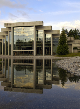 "This image shows the exterior of the Museum of Anthropology in Vancouver, with its distinctive architecture and surrounding outdoor totem poles representing Indigenous culture."