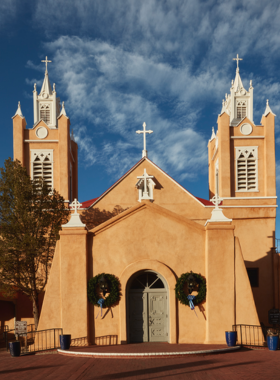 This image shows the historic San Felipe de Neri Church in Old Town Albuquerque, with its iconic adobe architecture