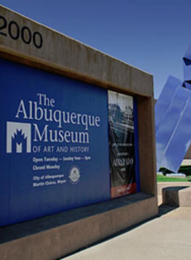 This image shows an exhibit of Pueblo pottery and Spanish armor at the Albuquerque Museum, highlighting local history and art.