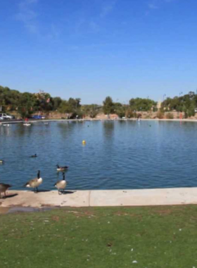 This image shows the calm waters of Tingley Beach, with people fishing and enjoying a peaceful day in Albuquerque.