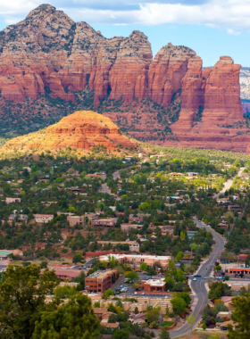 This image shows the striking red rock formations of Sedona, with clear blue skies above, offering visitors a chance to experience hiking trails, Jeep tours, and the peaceful energy of the desert landscape in Arizona