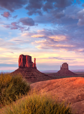 This image shows the iconic towering buttes and mesas of Monument Valley, set against a stunning desert backdrop. The image captures the beauty and cultural significance of this sacred Navajo landscape in Arizona.