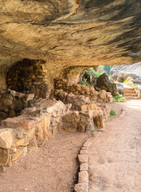 This image shows the ancient cliff dwellings at Walnut Canyon, Arizona, where visitors can explore the historic ruins built into the canyon walls, offering a glimpse into the lives of the Sinagua people who once inhabited the area.